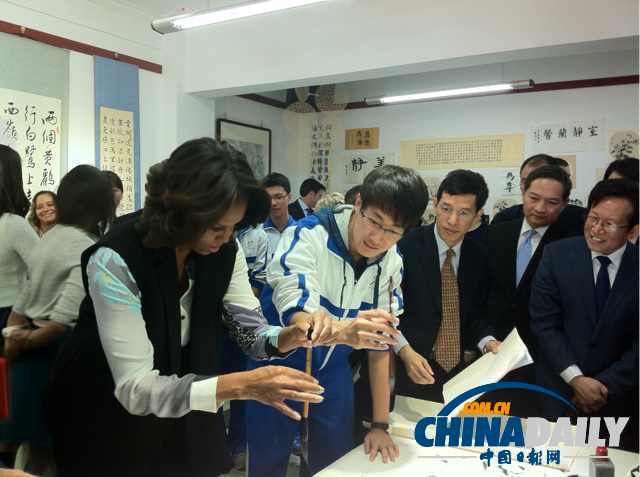 北京時間3月21日，美國第一夫人米歇爾參觀北師大二附中時，與學(xué)生一起練習(xí)書法。