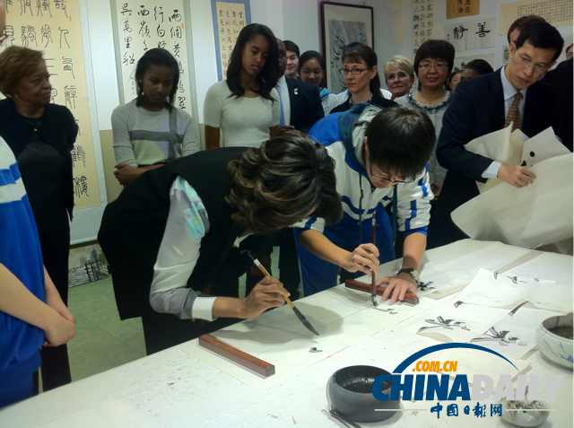 　北京時間3月21日，美國第一夫人米歇爾參觀北師大二附中時，與學(xué)生一起練習(xí)書法。