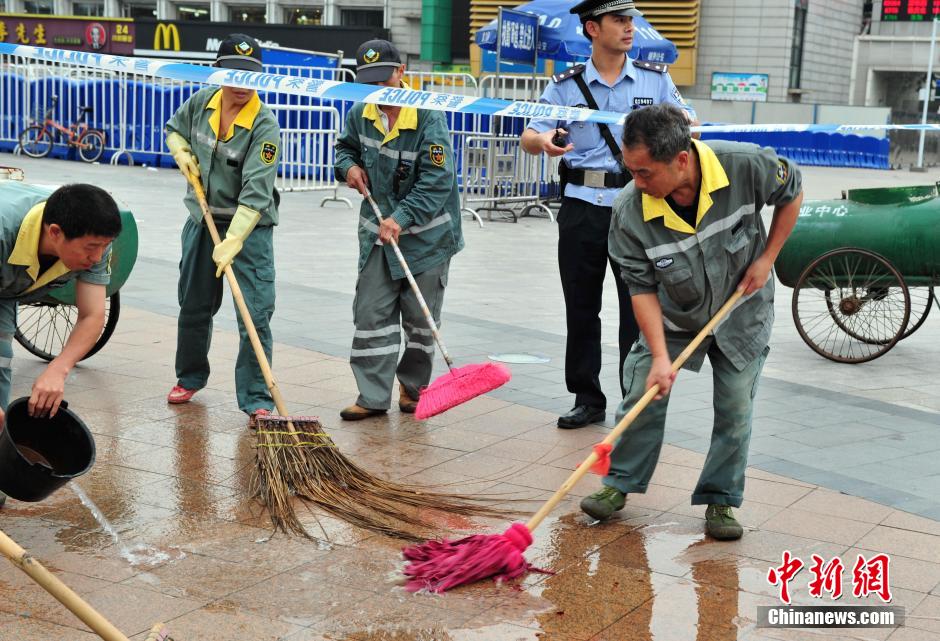 圖為環(huán)衛(wèi)工人在清理案發(fā)地點(diǎn)的血跡。