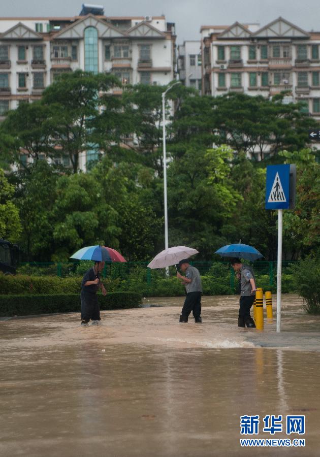 5月11日，人們在深圳西麗涉水行走。
