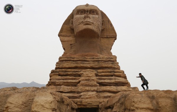 石家莊郊外，一名男子與山寨版獅身人面像合影留念。