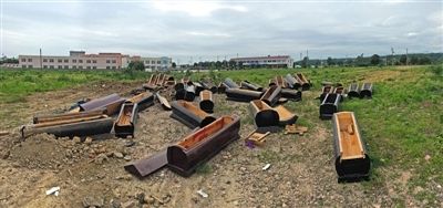 40多副棺木被砸壞后，扔在荒地上。