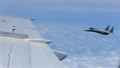 國防部網(wǎng)站12日公布的視頻截圖,日本F-15軍機從中國圖-154機頭方向危險切入,兩者最近距離約30米左右。