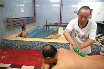 客人在搓澡。近日，百年歷史的鑫園浴池宣布將關(guān)張。新京報記者