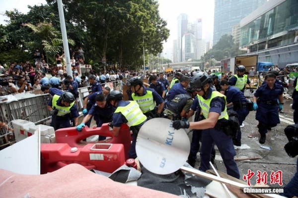 10月14日，警方清除金鐘道障礙物。大批警員在金鐘道現(xiàn)場清拆障礙物。部分警員戴上頭盔將障礙物移走。