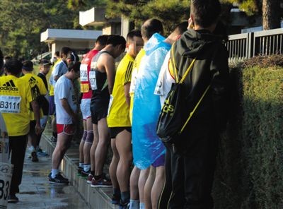 2013年10月20日，北京馬拉松比賽，由于廁位有限，一些選手在綠化帶“就地解決”。圖/IC
