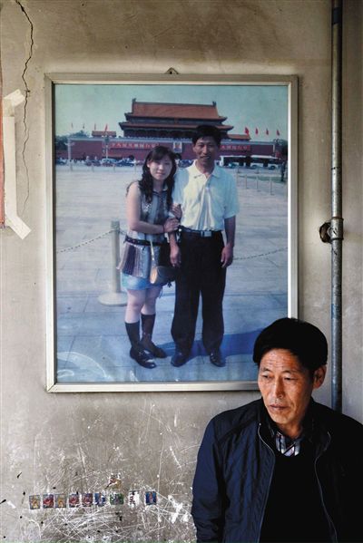 11月14日，承德市平泉縣，潘小梅父母的家，潘小梅父親靠在墻上，身后掛著數(shù)年前他和潘小梅在北京的合影照片。新京報(bào)記者