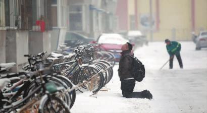 小伙子跪在樓前，一直抬頭看著樓上。 孫立國/攝