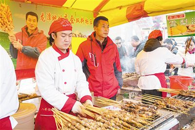 賣羊肉串?dāng)偽焕习遐w山（穿紅衣者）。新京報(bào)記者