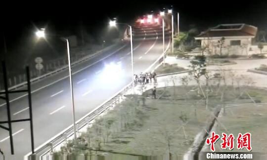 看到車輛經過，孩子們便急忙跑到一旁的花圃上?！【焦﹫D　攝