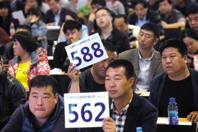 昨日，拍賣現(xiàn)場競拍者舉牌競拍。新京報記者