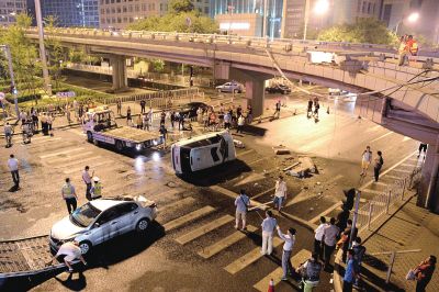 路虎沖下國(guó)貿(mào)橋砸中一輛起亞轎車，橋上厚達(dá)幾十厘米的水泥護(hù)欄被撞斷，碎石四處散落，數(shù)十群眾在現(xiàn)場(chǎng)圍觀。