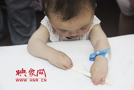 孩子握著筷子發(fā)呆。