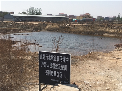 化肥廠滲坑的三分之一經(jīng)過治理，但水質(zhì)仍然呈黃褐色。