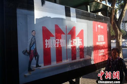 資料圖：11月1日，福州民眾從雙十一廣告牌前經(jīng)過。中新社記者 呂明 攝