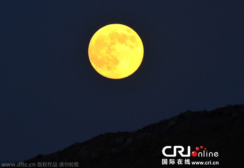 8月10日晚，一輪金燦燦的大月亮在遼寧省大連市東方升起。圖片來源：劉德斌/東方IC