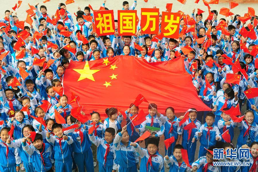 9月26日，安徽省阜陽市北城小學(xué)分校的學(xué)生與國旗合影。
