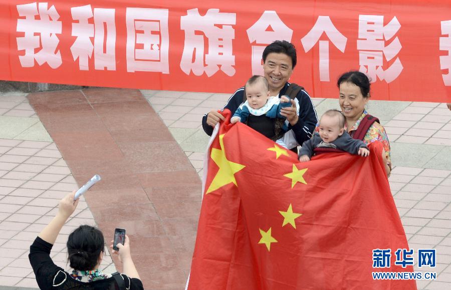 9月27日，在山東德州市中心廣場(chǎng)，市民與國旗合影。
