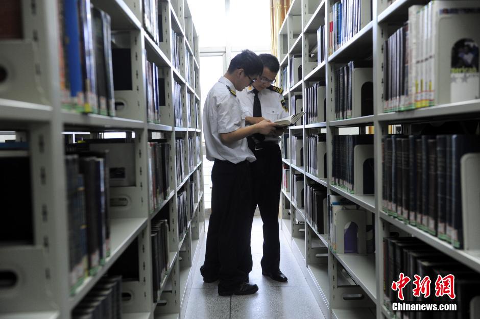 5月8日，武漢輕工大學保安吳濤與江力在圖書館交流學習。中新社發(fā) 張暢 攝
