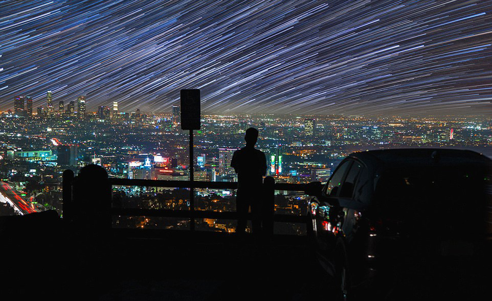 照片中，一名男子看著流星和隕星劃過天空。（網(wǎng)頁截圖）