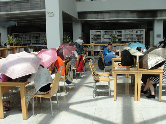 圖書館內(nèi)撐傘讀書的民眾。