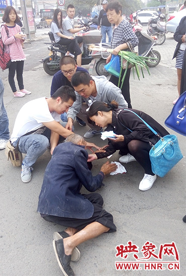 一些愛(ài)心市民在撥打了110和120后，上前給老人擦臉上的血跡。