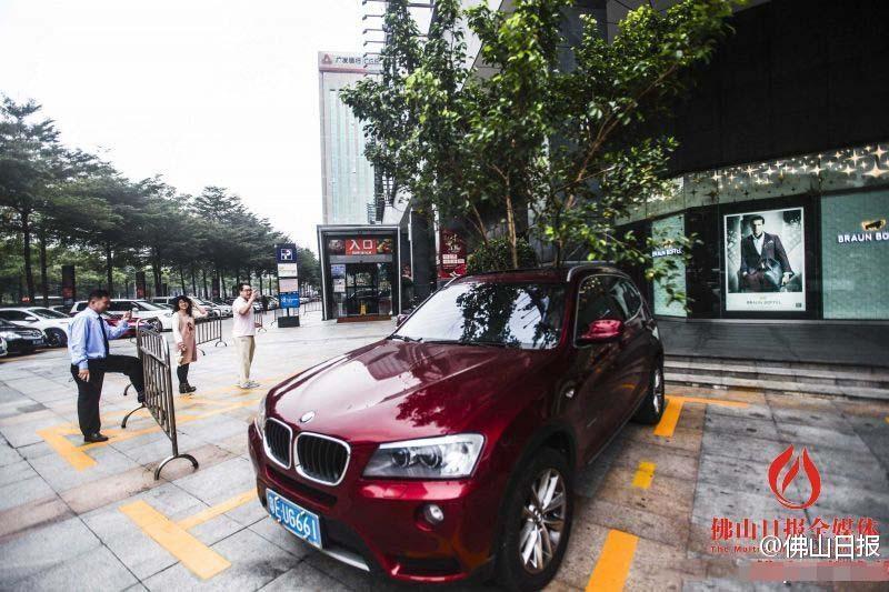 一輛停在停車(chē)位上的寶馬轎車(chē)，被墜落的樹(shù)枝砸中，樹(shù)枝徑直插入車(chē)內(nèi)，現(xiàn)場(chǎng)引發(fā)不少市民圍觀拍照。
