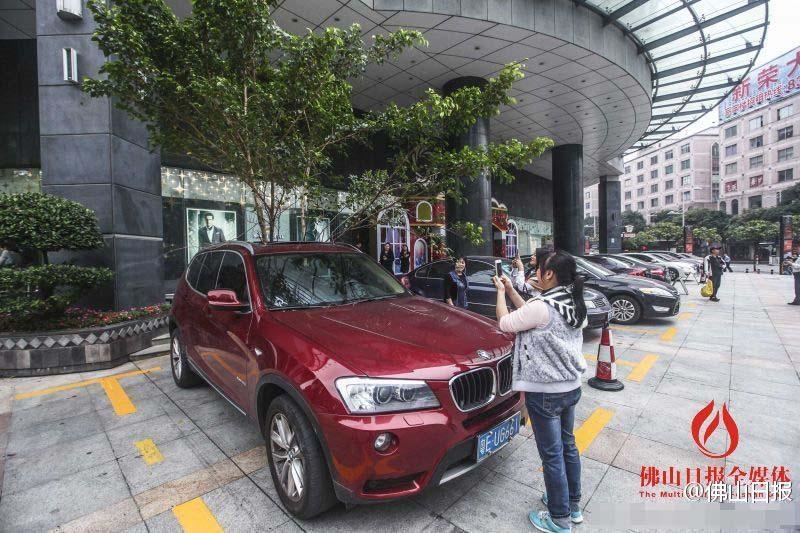 一輛停在停車(chē)位上的寶馬轎車(chē)，被墜落的樹(shù)枝砸中，樹(shù)枝徑直插入車(chē)內(nèi)，現(xiàn)場(chǎng)引發(fā)不少市民圍觀拍照。