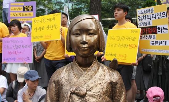 7月2日，在韓國首爾的日本駐韓國大使館前，民眾在慰安婦少女像旁手持標(biāo)語參加抗議活動(dòng)。