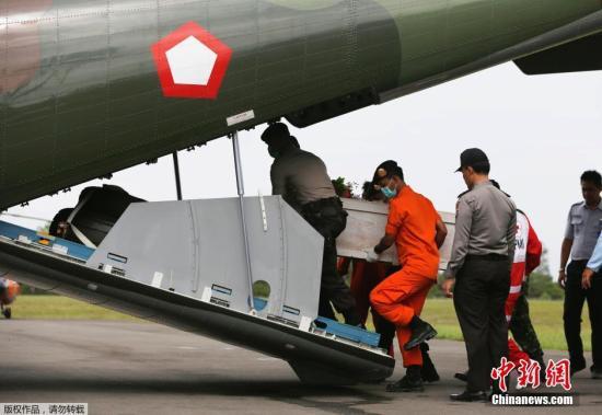 資料圖：當(dāng)?shù)貢r間2015年1月19日，印尼龐卡蘭布翁，依斯干達空軍基地，救援隊成員正將裝有亞航失事飛機遇難者尸體的棺材抬上一架CN2950運輸機。