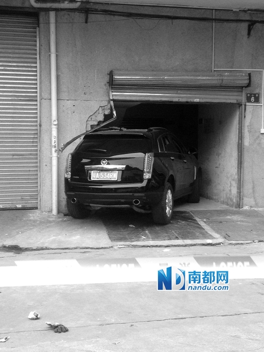 　昨日，凱迪拉克撞人后停在一倉(cāng)庫(kù)門口，車后有一攤血跡。 南都記者陳杰生攝
