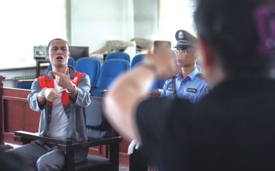 張志國在法庭上用手語回答提問。記者 蒲東峰攝