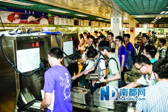 昨日，華南理工大學(xué)一食堂內(nèi)，學(xué)生們正在使用新安裝的自動(dòng)打飯機(jī)打飯。中新社發(fā)