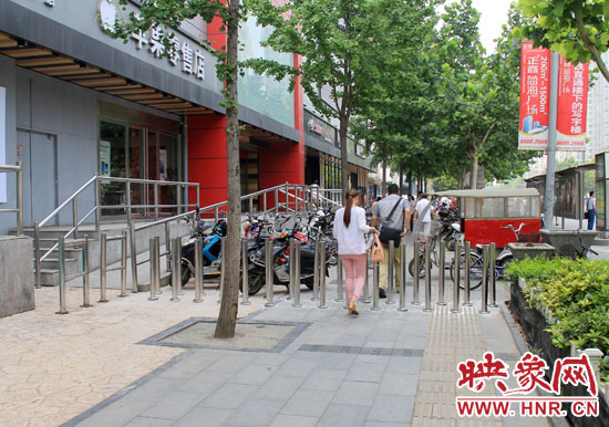 圖中道路左側(cè)的無障礙通道被鋼管隔離,右側(cè)的盲道也被侵占。