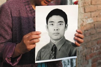 5月19日，朝陽(yáng)北路，母親捧著張東文的遺像。新京報(bào)記者 侯少卿 攝