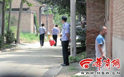 昨日，西安市閻良區(qū)譚家村，警方在事發(fā)的孫某家里勘查現場后，將提取的物證帶走 記者 黃利健 攝