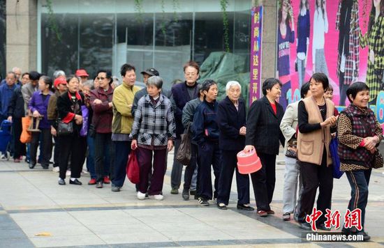 圖為10月28日，在江西九江市一家羊絨皮草服裝服飾博覽會(huì)現(xiàn)場(chǎng)，老人們正在頂著寒風(fēng)排隊(duì)等待領(lǐng)取10元代金劵。