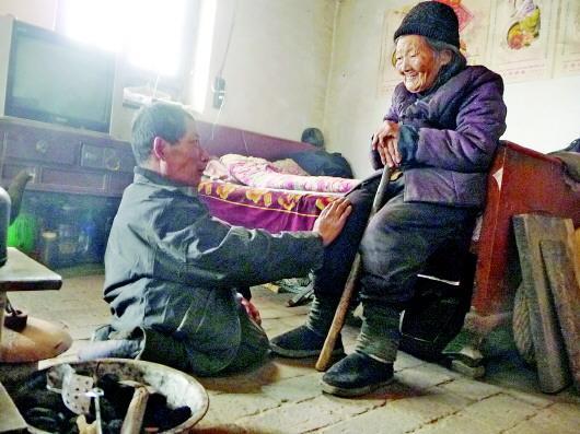 52歲的劉蘭山每天靠爬行照顧90歲的老母親。孫國祥 攝