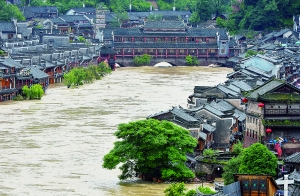 7月16日,沱江兩邊的商鋪和遠(yuǎn)處的虹橋仍淹沒在洪水中。 新華社發(fā)