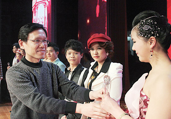 2013年2月1日，《對(duì)9當(dāng)歌》總決賽在鄭州開(kāi)唱。圖為東方今報(bào)副社長(zhǎng)胡楊為選手頒獎(jiǎng)