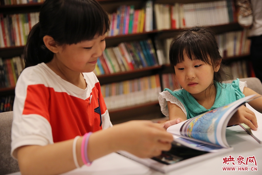 姐姐王藝茹，11歲，小學(xué)五年級學(xué)生；妹妹王有君，5歲：像喜歡看電視一樣喜歡看書。