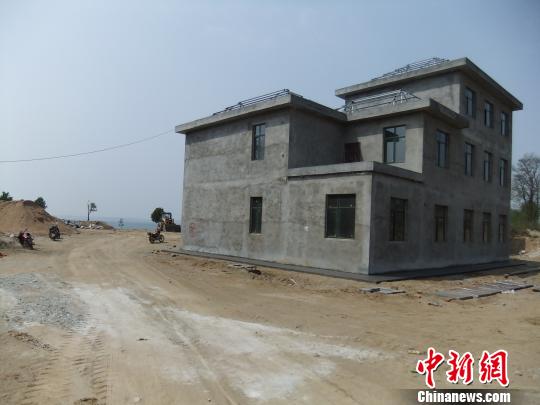 鴨河水庫庫區(qū)邊的新建別墅，一面墻上寫著“拆”，另一邊在加緊施工。吳揚(yáng)　攝