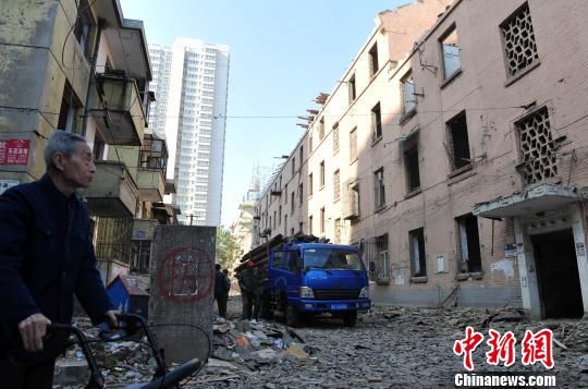 一位花甲老人站在即將拆除的樓房旁，默默地與“蘇聯(lián)樓”告別。　翟羽佳　攝